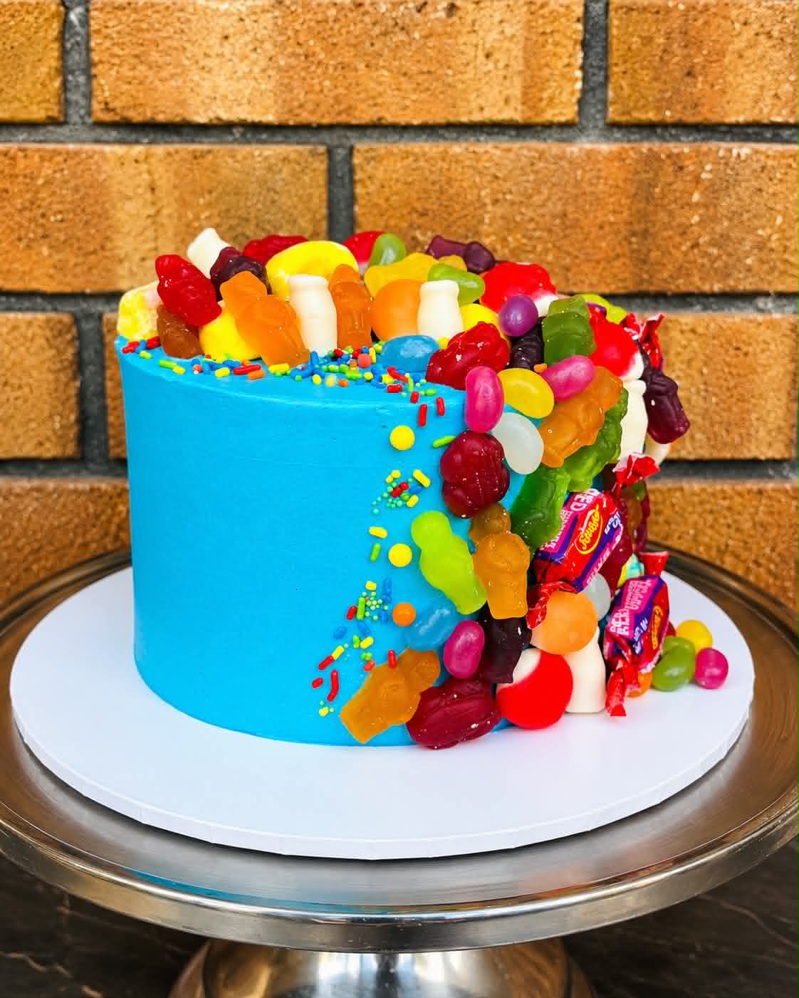 Blue birthday cake loaded with colourful lollies, gummy bears, jelly beans and sprinkles